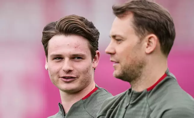 Bayern's goalkeeper Jonas Urbig, left, watches Bayern's goalkeeper Manuel Neuer during a training session ahead of the Champions League quarterfinal second leg soccer match between Bayern Munich and Real Madrid in Munich, Germany, Tuesday, April 14, 2026. (AP Photo/Matthias Schrader)