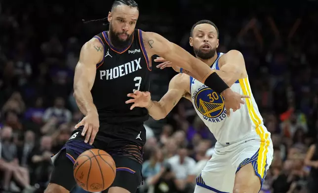 Phoenix Suns forward Dillon Brooks drives past Golden State Warriors guard Stephen Curry (30) during the second half of an NBA basketball play-in tournament game, Friday, April 17, 2026, in Phoenix. (AP Photo/Rick Scuteri)