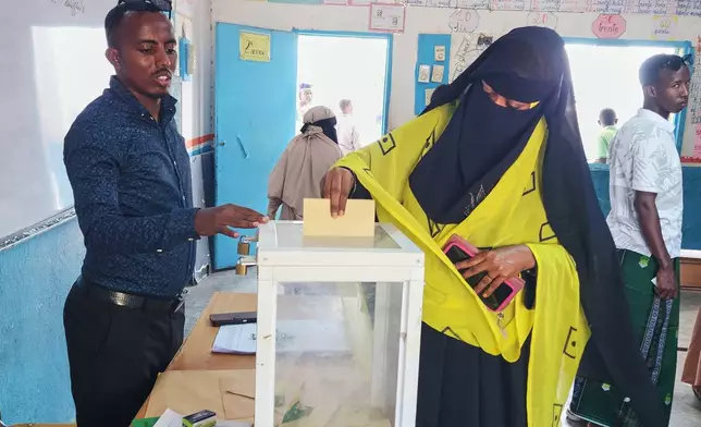 A woman casts her vote at a polling station during early voting in the presidential elections, in Mouloud, Djibouti, Friday, April 10, 2026. (AP Photo/Guirreh Moumin)