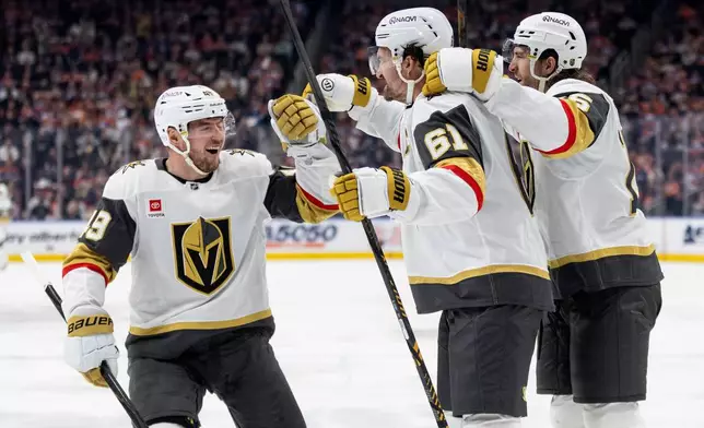 Vegas Golden Knights' Ivan Barbashev (49), Mark Stone (61) and Noah Hanifin (15) celebrate a goal against the Edmonton Oilers during the third period of an NHL hockey game in Edmonton, Alberta, on Saturday, April 4, 2026. (Jason Franson/The Canadian Press via AP)