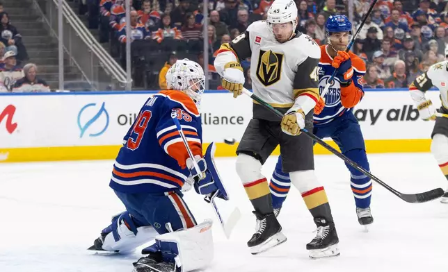 Vegas Golden Knights' Ivan Barbashev (49) and Edmonton Oilers' Darnell Nurse (25) look for the rebound from goalie Connor Ingram (39) during first period NHL action, in Edmonton on Saturday, April 4, 2026. (Jason Franson/The Canadian Press via AP)