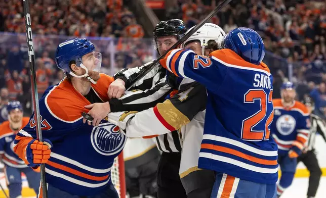 Vegas Golden Knights' Rasmus Andersson (4) roughs it up with Edmonton Oilers' Connor McDavid (97) and Matt Savoie (22) during the second period of an NHL hockey game in Edmonton, Alberta, on Saturday April 4, 2026. (Jason Franson/The Canadian Press via AP)
