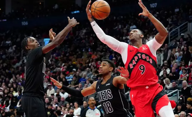 Toronto Raptors forward RJ Barrett (9) scoops the rebound from Brooklyn Nets forward Trevon Scott (13) as teammate Malachi Smith (18) looks on during first half NBA basketball action in Toronto, Sunday, April 12, 2026.(Frank Gunn/The Canadian Press via AP)