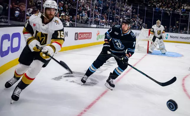 Vegas Golden Knights defenseman Noah Hanifin (15) and Utah Mammoth right wing JJ Peterka (77) look to play the puck along the boards during the first period of Game 4 of a first-round NHL hockey Stanley Cup playoff series, Monday, April 27, 2026, in Salt Lake City. (AP Photo/Tyler Tate)