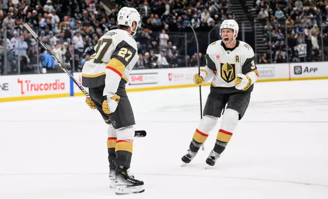Vegas Golden Knights Brayden McNabb, right, celebrates with Shea Theodore, left, who scored the winning goal during the overtime period of Game 4 of a first-round NHL hockey Stanley Cup playoff series against the Utah Mammoth, Monday, April 27, 2026, in Salt Lake City. (AP Photo/Tyler Tate)