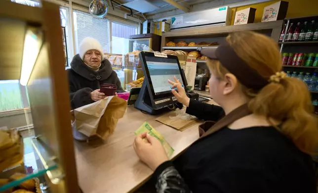 FILE- A customer buys bread at the Mashenka bakery outside Moscow, Russia, on Feb. 18, 2026. (AP Photo/Alexander Zemlianichenko, File)