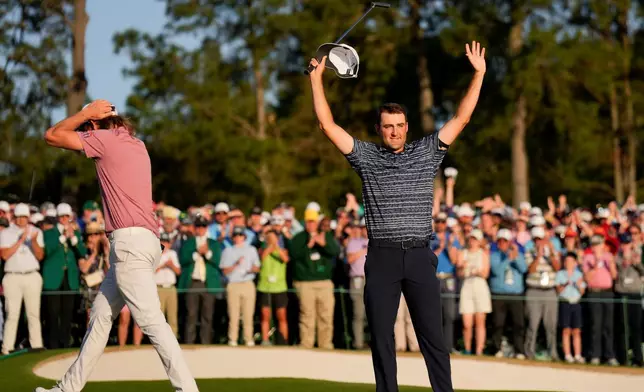 FILE - Cameron Smith, of Australia, walks past as Scottie Scheffler celebrates after winning the 86th Masters golf tournament on April 10, 2022, in Augusta, Ga. (AP Photo/Matt Slocum, File)