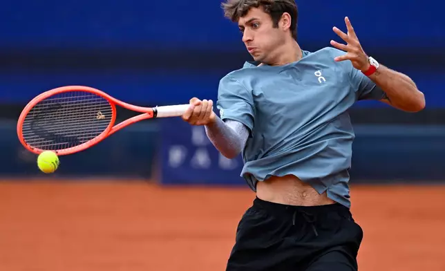 Italy's Flavio Cobolli in action against Ben Shelton of the US during the men's singles final match at the ATP Tour in Munich, Germany, Sunday April 19, 2026. (Sven Hoppe/dpa via AP)