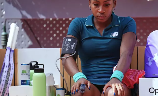 Coco Gauff of the United States receives medical attention during her match against Sorana Cirstea of Romania at the Madrid Open tennis tournament, Sunday, April 26, 2026, in Madrid. (AP Photo/Manu Fernandez)