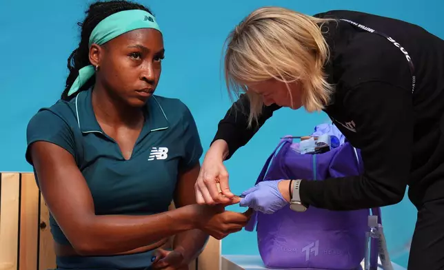 Coco Gauff of the U.S. receives medical attention during her match against Leolia Jeanjean of France during the Madrid Open tennis tournament in Madrid, Friday, April 24, 2026. (AP Photo/Manu Fernandez)