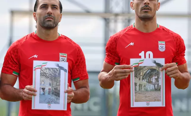 Iran's Saman Ghoddos, left, and Ali Nemati hold pictures of children allegedly killed in a U.S. and Israel strikes in Iran, before a friendly soccer match between Iran and Costa Rica, in Antalya, southern Turkey, Tuesday, March 31, 2026. (AP Photo/Riza Ozel)