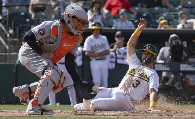Houston Astros catcher Yainer Diaz (21) attempts to get Athletics' Max Muncy (3) out at home during the seventh inning of a baseball game Sunday, April 5, 2026, in West Sacramento, Calif. (AP Photo/Sara Nevis)