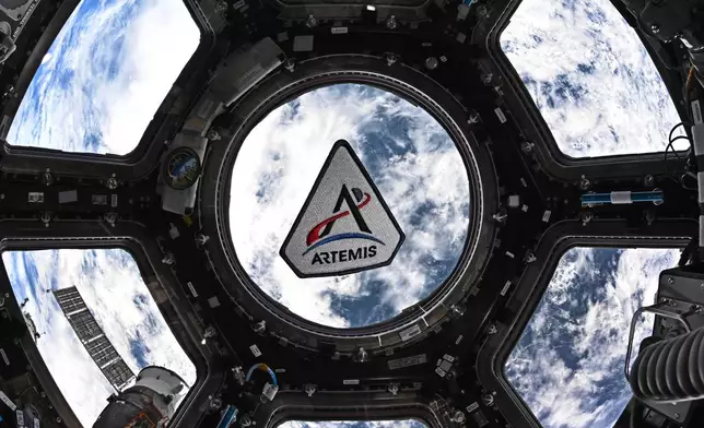 In this photo provided by NASA, an Artemis program patch floating in the International Space Station's cupola, on March 30, 2026. (Jessica Meir/NASA via AP)