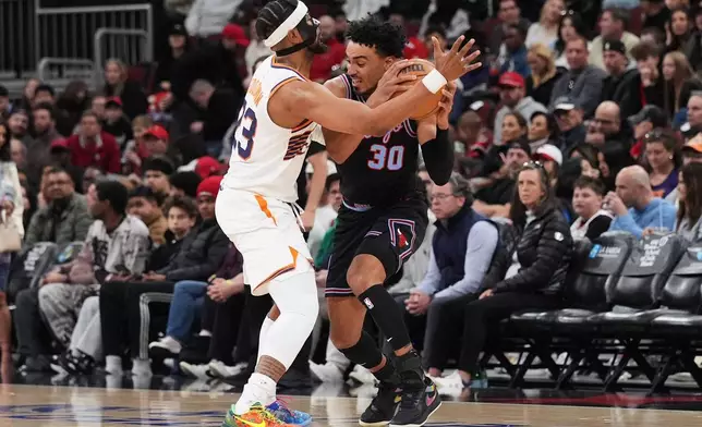 Phoenix Suns guard Jordan Goodwin, left, defends Chicago Bulls guard Tre Jones during the first half of an NBA basketball game in Chicago, Sunday, April 5, 2026. (AP Photo/Nam Y. Huh)