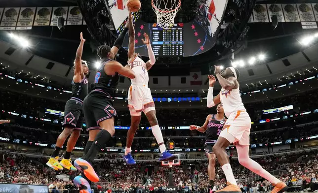 Phoenix Suns guard Jalen Green (4) drives to the basket past Chicago Bulls forward Guerschon Yabusele (28) and guard Collin Sexton, left, during the first half of an NBA basketball game, in Chicago, Sunday, April 5, 2026. (AP Photo/Nam Y. Huh)