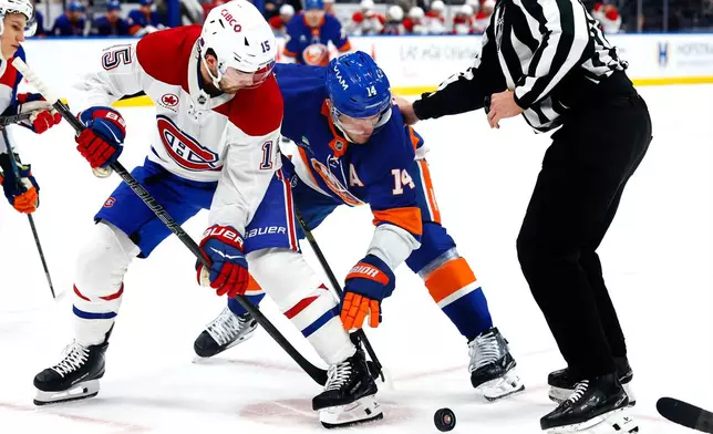 Montréal Canadiens center Alex Newhook (15) battles New York Islanders center Bo Horvat (14) for the puck during the second period of an NHL hockey game, Sunday, April 12, 2026, in Elmont, N.Y. (AP Photo/Noah K. Murray) CORRECTION: Corrects to Elmont, N.Y., not New York.