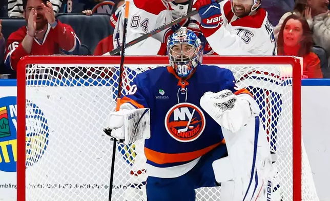 Montréal Canadiens David Reinbacher (64) celebrates with center Alex Newhook (15) after scoring a goal against New York Islanders goaltender Ilya Sorokin (30) during the second period of an NHL hockey game, Sunday, April 12, 2026, in Elmont, N.Y. (AP Photo/Noah K. Murray)