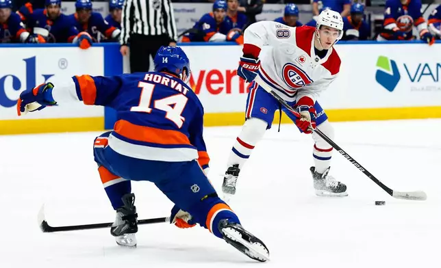 Montréal Canadiens defenseman Lane Hutson (48) plays the puck against New York Islanders center Bo Horvat (14) during the first period of an NHL hockey game, Sunday, April 12, 2026, in New York. (AP Photo/Noah K. Murray)