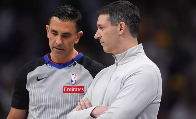Oklahoma City Thunder head coach Mark Daigneault, front, confers with referee Zach Zarba in the first half of an NBA basketball game against the Denver Nuggets Friday, April 10, 2026, in Denver. (AP Photo/David Zalubowski)
