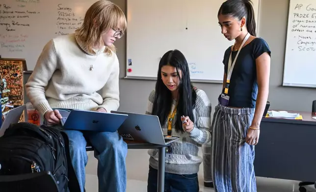 Fayetteville High senior Lily Adler, center, president of the Young Democrats of Arkansas, talks to club officers including Miller Rawn, left, and Mira Brock, right, during an officers meeting Tuesday April, 7, 2026 in Fayetteville, Ark. (AP Photo/Michael Woods) CORRECTION: Adler, not Alder