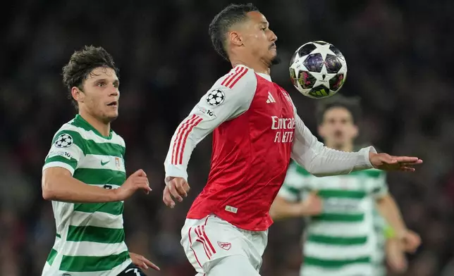 Arsenal's William Saliba, front, and Sporting's Eduardo Quaresma pfp during the UEFA Champions League second leg quarterfinal soccer match between Arsenal and Sporting in London, England, Wednesday, April 15, 2026. (AP Photo/Kin Cheung)