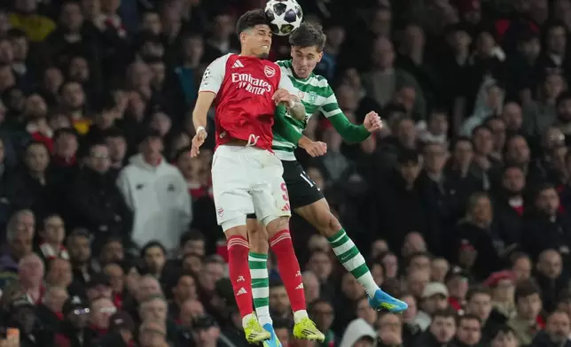 Arsenal's Piero Hincapie, left, and Sporting's Georgios Vagiannidis jump for the ball during the UEFA Champions League second leg quarterfinal soccer match between Arsenal and Sporting in London, England, Wednesday, April 15, 2026. (AP Photo/Kin Cheung)