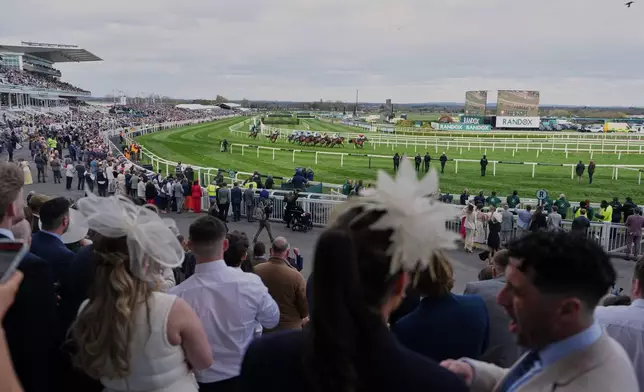 Crowds watch the racing on Ladies Day, the second day of the Grand National Horse Racing festival, at Aintree racecourse, near Liverpool, England, Friday, April 10, 2026. (AP Photo/Jon Super)
