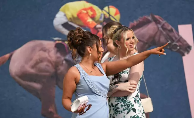 Members of the public arrive to attend Ladies Day, the second day of the Grand National Horse Racing festival, at Aintree racecourse, near Liverpool, England, Friday, April 10, 2026. (AP Photo/Jon Super)