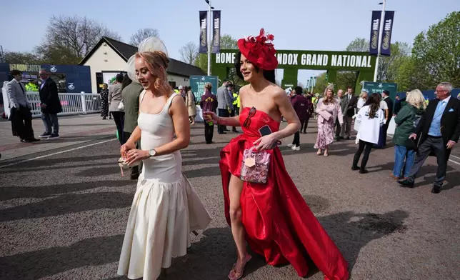 Racegoers arrive to attend Ladies Day, the second day of the Grand National Horse Racing festival, at Aintree racecourse, near Liverpool, England, Friday, April 10, 2026. (AP Photo/Jon Super)