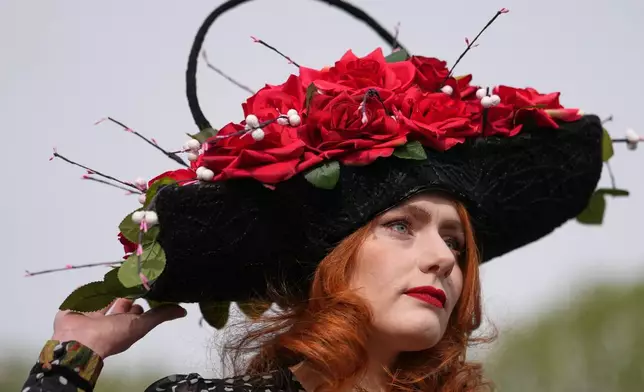 Charlotte Hawes wears a hat by House of Charles as she arrives to attend Ladies Day, the second day of the Grand National Horse Racing festival, at Aintree racecourse, near Liverpool, England, Friday, April 10, 2026. (AP Photo/Jon Super)
