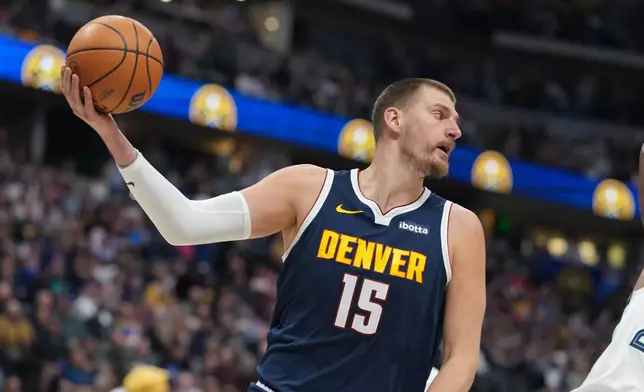 Denver Nuggets center Nikola Jokić pulls in a loose ball in the first half of an NBA basketball game against the Memphis Grizzlies Wednesday, April 8, 2026, in Denver. (AP Photo/David Zalubowski)
