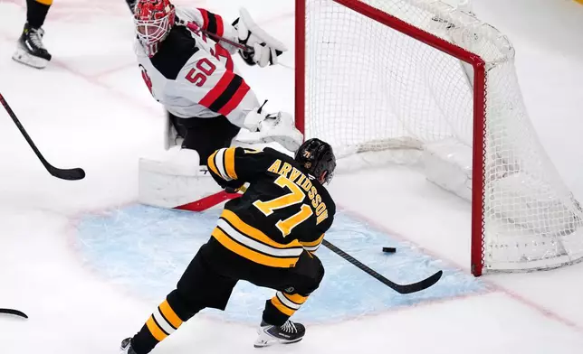 Boston Bruins left wing Viktor Arvidsson (71) scores on New Jersey Devils goaltender Nico Daws (50) during the first period of a hockey game, Tuesday, April 14, 2026, in Boston. (AP Photo/Charles Krupa)