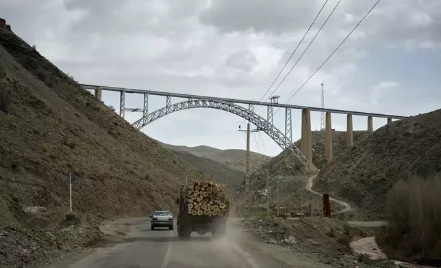 A truck loaded with logs and other vehicles drive along a road toward Tehran near the Turkish border on the outskirts of Razi, northwestern Iran, Saturday, April 4, 2026. (AP Photo/Francisco Seco)