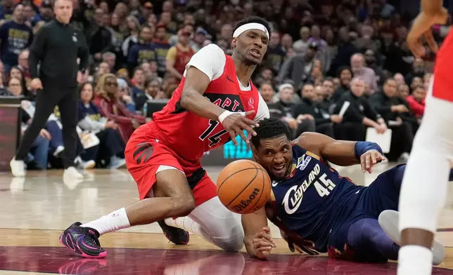 Toronto Raptors guard Ja'kobe Walter (14) and Cleveland Cavaliers guard Donovan Mitchell (45) reach for the ball in the second half in Game 2 of a first-round NBA basketball playoffs series in Cleveland, Monday, April 20, 2026. (AP Photo/Sue Ogrocki)