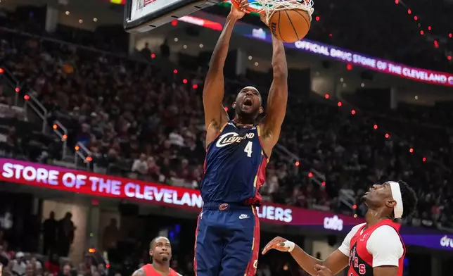 Cleveland Cavaliers center Evan Mobley (4) dunks next to Toronto Raptors guard Ja'kobe Walter, right, in the second half in Game 2 of a first-round NBA basketball playoffs series in Cleveland, Monday, April 20, 2026. (AP Photo/Sue Ogrocki)