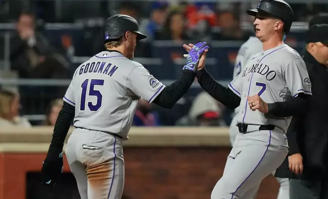 Colorado Rockies' TJ Rumfield (7) celebrates with Hunter Goodman (15) after they score on a single byu Troy Johnston during the seventh inning of a baseball game against the New York Mets Friday, April 24, 2026, in New York. (AP Photo/Frank Franklin II)