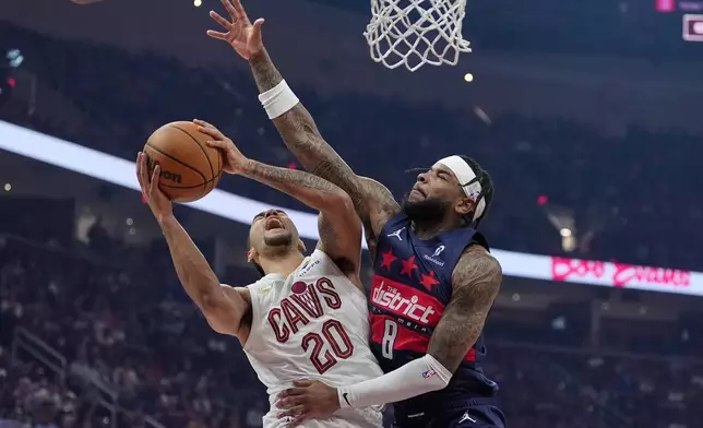 Cleveland Cavaliers guard Jaylon Tyson (20) shoots as Washington Wizards guard Jaden Hardy (8) defends in the first half of an NBA basketball game in Cleveland, Sunday, April 12, 2026. (AP Photo/Sue Ogrocki)