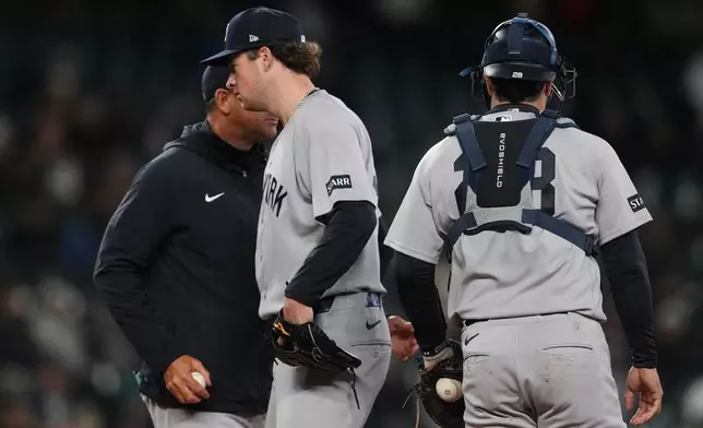 New York Yankees head coach Aaron Boone, left, arrives on the mound to take New York Yankees starting pitcher Cam Schlittler out of the game against the Seattle Mariners during the seventh inning of a baseball game, Wednesday, April 1, 2026, in Seattle. (AP Photo/Lindsey Wasson)