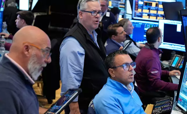 People work on the floor at the New York Stock Exchange in New York, Monday, March 30, 2026. (AP Photo/Seth Wenig)