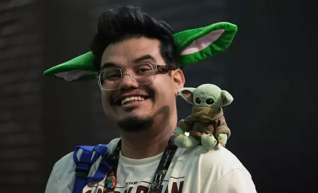 A man carries a Grogu plush toy on his shoulder at CCXP Mexico in Mexico City, Sunday, April 26, 2026. (AP Photo/Ginnette Riquelme)