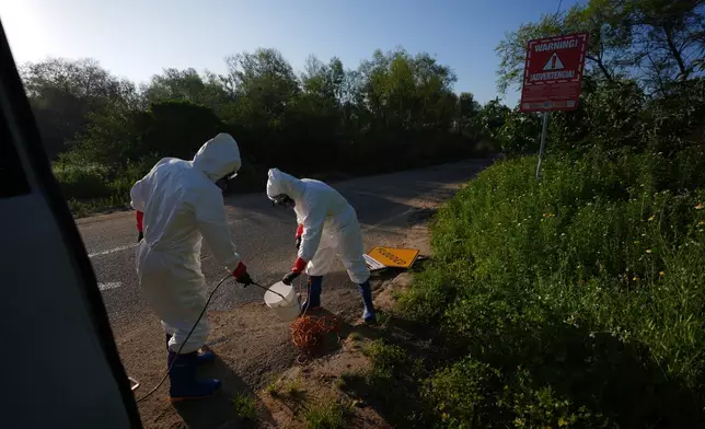 Trent Fry, right, and Leila El Masri clean a bucket after collecting a water sample of the Tijuana River, as part of a research team from the University of California, San Diego, Wednesday, March 11, 2026, in San Diego. (AP Photo/Gregory Bull)