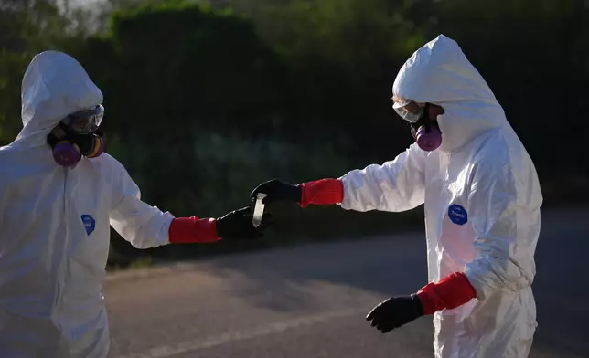 Trent Fry, right, and Leila El Masri handle a water sample of the Tijuana River, as part of a research team from the University of California, San Diego, Wednesday, March 11, 2026, in San Diego. (AP Photo/Gregory Bull)