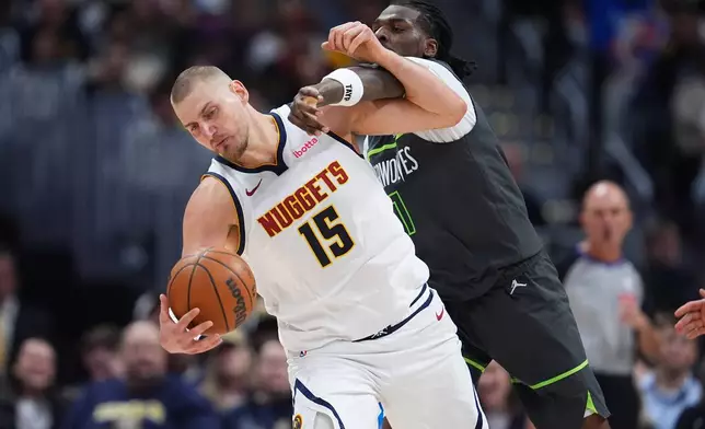 Minnesota Timberwolves center Naz Reid, right, gets called for a foul as Denver Nuggets center Nikola Jokic fields a pass in the second half in Game 1 of a first-round NBA playoffs basketball series, Saturday, April 18, 2026, in Denver. (AP Photo/David Zalubowski)