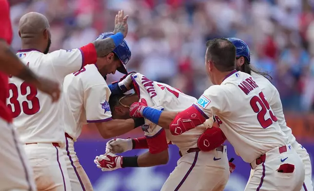 Philadelphia Phillies' Justin Crawford, center, celebrates teammates after they won a baseball game against the Washington Nationals, Wednesday, April 1, 2026, in Philadelphia. (AP Photo/Matt Rourke)
