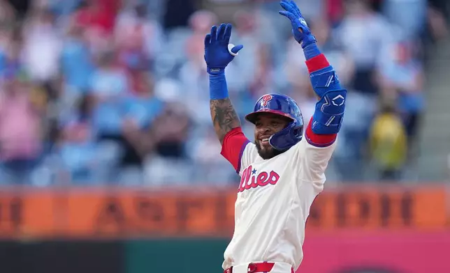 Philadelphia Phillies' Edmundo Sosa reacts from second base after hitting a two-run single off of Washington Nationals pitcher Cole Henry during the ninth inning of a baseball game, Wednesday, April 1, 2026, in Philadelphia. (AP Photo/Matt Rourke)