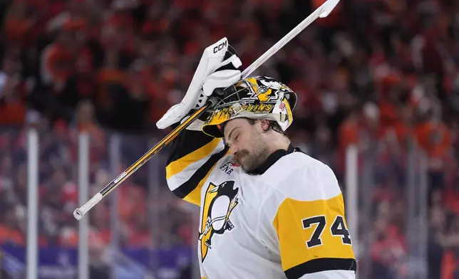 Pittsburgh Penguins' Stuart Skinner adjusts his mask during the second period of Game 3 against the Philadelphia Flyers in the first round of the NHL Stanley Cup hockey playoffs Wednesday, April 22, 2026, in Philadelphia. (AP Photo/Matt Slocum)