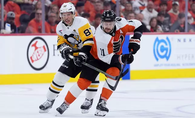 Philadelphia Flyers' Travis Konecny, right, tries to keep the puck away from Pittsburgh Penguins' Sidney Crosby during the second period of Game 3 in the first round of the NHL Stanley Cup hockey playoffs Wednesday, April 22, 2026, in Philadelphia. (AP Photo/Matt Slocum)