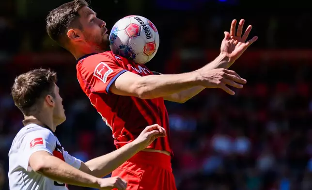 Heidenheim's Marvin Pieringer, right, and St. Pauli's Arkadiusz Pyrka during the German Bundesliga soccer match between 1. FC Heidenheim and 1. FC St. Pauli in Heidenheim, Germany, Saturday, April 25, 2026. (Tom Weller/dpa via AP)