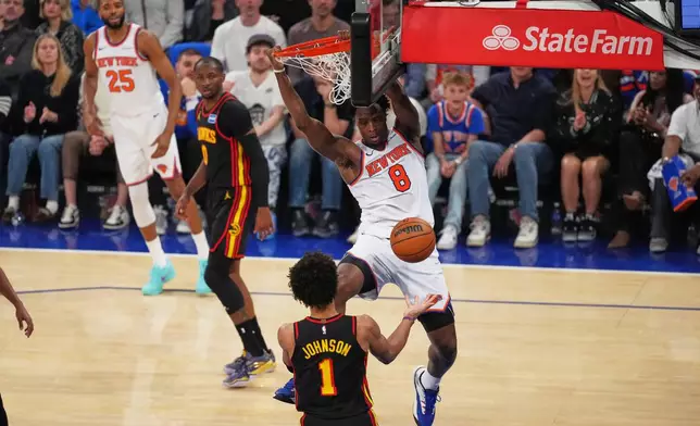 New York Knicks' Og Anunoby (8) dunks the ball in front of Atlanta Hawks' Jalen Johnson (1) during the first half in Game 1 of a first-round NBA playoffs basketball series, Saturday, April 18, 2026, in New York. (AP Photo/Frank Franklin II)