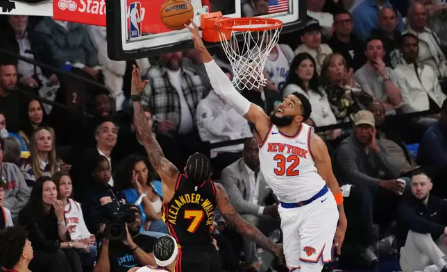 New York Knicks' Karl-Anthony Towns (32) blocks a shot by Atlanta Hawks' Nickeil Alexander-Walker (7) during the first half in Game 1 of a first-round NBA playoffs basketball series, Saturday, April 18, 2026, in New York. (AP Photo/Frank Franklin II)